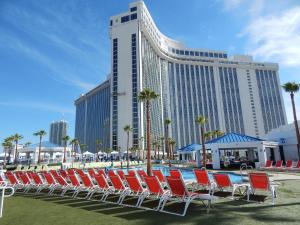 einer Gruppe von Stühlen und einem Pool vor einem Hotel in der Unterkunft Westgate Las Vegas Resort and Casino in Las Vegas
