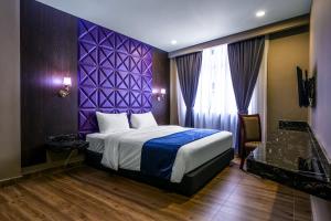 a bedroom with a bed, a dresser, and a window at U3 HOTEL in Subang Jaya