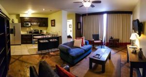a living room with a blue couch and a kitchen at Humuya Inn in Tegucigalpa