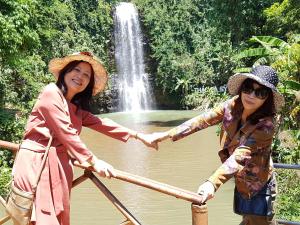 two women on a boat in front of a waterfall at Bac Huong Hotel in Kon Tum (2)