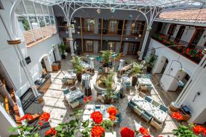 um pátio interior com mesas, cadeiras e flores em Mama Cuchara by Art Hotels em Quito