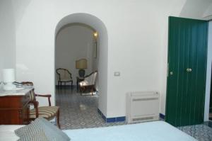 a room with a green door and a table and chairs at Hotel Parsifal - Antico Convento del 1288 in Ravello
