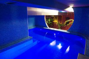 eine blaue Badewanne in einem Zimmer mit Spiegel in der Unterkunft Rubin Hotel Complex in Jakutsk