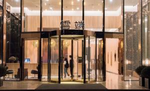 a lobby with a woman walking in a store at The Clouds Apartment in Shenzhen