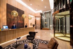 a lobby with two men standing at a reception desk at The Clouds Apartment in Shenzhen