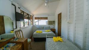 a room with two beds and a table and a desk at Ryan's Rest Boutique Accommodation in Cairns +36 photos