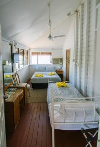 a bedroom with two beds and a desk at Ryan's Rest Boutique Accommodation in Cairns