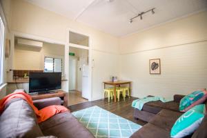 a living room with a couch and a flat screen tv at Ryan's Rest Boutique Accommodation in Cairns