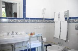 a bathroom with a sink and a toilet and a mirror at Hotel Parsifal - Antico Convento del 1288 in Ravello