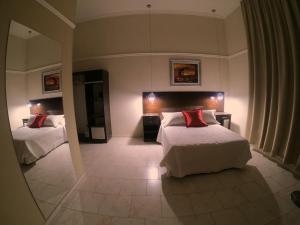 Habitación de hotel con 2 camas y espejo en Eclat Suites Hotel Boutique en Villa Mercedes