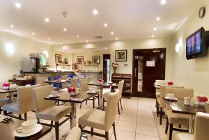 restauracja ze stołami i krzesłami oraz kuchnia w obiekcie The Premier Notting Hill w Londynie