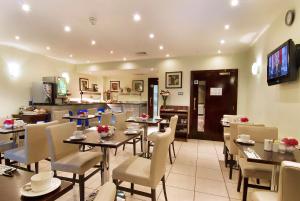 a restaurant with tables and chairs and a kitchen at The Premier Notting Hill in London