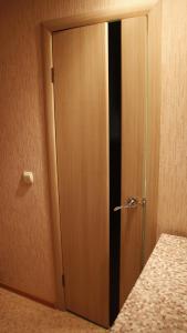 トムスクにあるApartments on Frunze 126のベッドの横の部屋の木製ドア