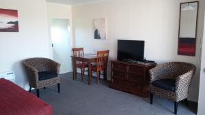 a room with a television and a table and chairs at Mount Hutt Motels in Methven