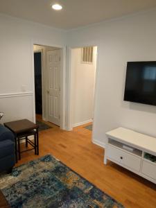 a living room with a flat screen tv on a wall at University City Guest House in Charlotte