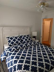 a bedroom with a blue and white comforter on a bed at University City Guest House in Charlotte