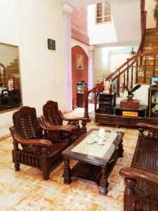 a living room with chairs and a table and a piano at Private room, international area, near Airport in Hai Phong