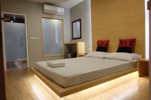 a bedroom with a large white bed with red pillows at Love Box Resort in Samutprakarn +28 photos