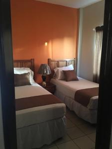 una habitación de hotel con 2 camas y una lámpara en Apartamentos del Puerto, en Tela