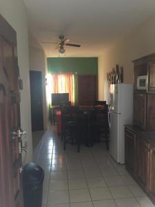 una cucina con un tavolo e un frigorifero bianco di Apartamentos del Puerto a Tela