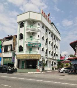 um grande edifício branco com um cartaz em Kangsar Hotel em Kuala Kangsar