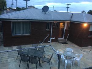 a patio with a table and chairs and a house at Home & Away St Leonards in Saint Leonards