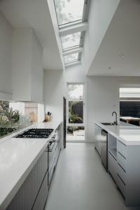 ショール・ベイにあるSalt at Shoal Bayの白いカウンターとコンロ付きオーブンのあるキッチン