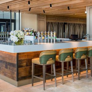 un bar con sillas verdes y una barra en The William Inglis Mgallery, en Warwick Farm 151 fotos más