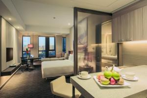 Pan Pacific Tianjin في تيانجين: غرفة فندق فيها سرير وطاولة عليها فاكهة