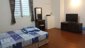 een slaapkamer met een bed en een flatscreen-tv bij A-Ma Homestay in Fengli
