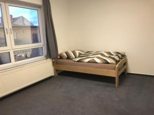 a bed sitting in a room next to a window at Am Bahnhof in Lutherstadt Wittenberg