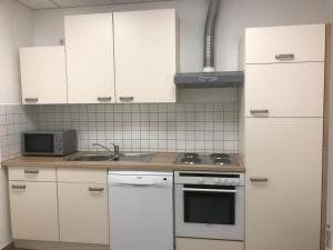 a kitchen with white cabinets and a stove top oven at Am Bahnhof in Lutherstadt Wittenberg