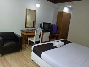 a hotel room with a bed and a chair and a desk at Thai Inter Korat Hotel in Nakhon Ratchasima