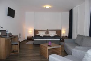 salon z łóżkiem i kanapą w obiekcie Glas-Hotel 3* w mieście Żary
