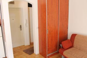 soggiorno con armadio in legno e sedia di Calm Apartment a Belgrado