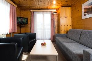 a living room with a couch and a table at Haus Aristella in Saas-Fee