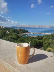 una taza de café sentada en una cornisa con vistas al agua en Hostel **Casa del Sole**, en Klenovica