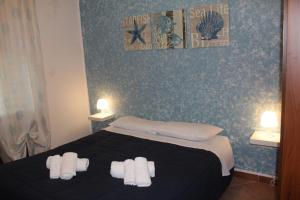 1 dormitorio con 1 cama negra y 2 toallas blancas en Torre Sances Holiday Apartament, en Birgi Vecchi