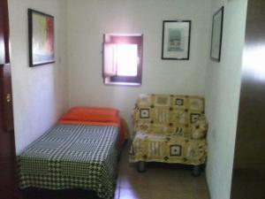Habitación pequeña con cama y silla en La Mia Casa Sulla Collina, en Valsinni