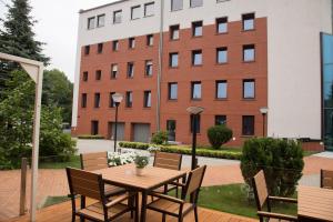 a wooden table and chairs in front of a building at Glas-Hotel 3* in Żary