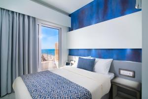 a bedroom with a bed and a large window at Molos Hotel in Limenaria