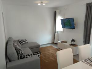uma sala de estar com um sofá e uma televisão em City Comfort em Estepona