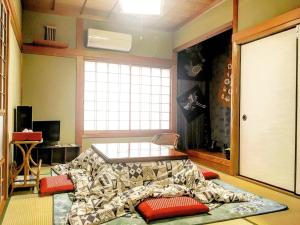 Schlafzimmer mit einem Bett, einem Tisch und einem Fenster in der Unterkunft MaruHouse in Nachikatsuura