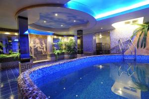 a swimming pool in a hotel room with a large swimming pool at Отель Фараон in Kyiv