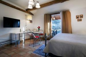a bedroom with a bed and a table and a kitchen at Hotel Autantic in Bourg-Saint-Maurice