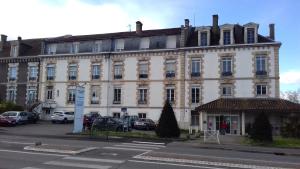 um grande edifício branco no lado de uma rua em Hôtel Labat em Orthez