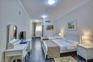 a hotel room with two beds and a television at Royal Hotel in Sharjah