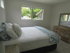 Un dormitorio con una cama grande y una ventana en The Palms at Point Wells en Big Omaha