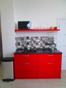 a kitchen with red cabinets and a black counter top at Arena,VIP in Kyiv