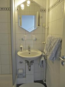 uma casa de banho com um lavatório, um WC e um espelho. em Ferienwohnung Schlosser em Schleswig